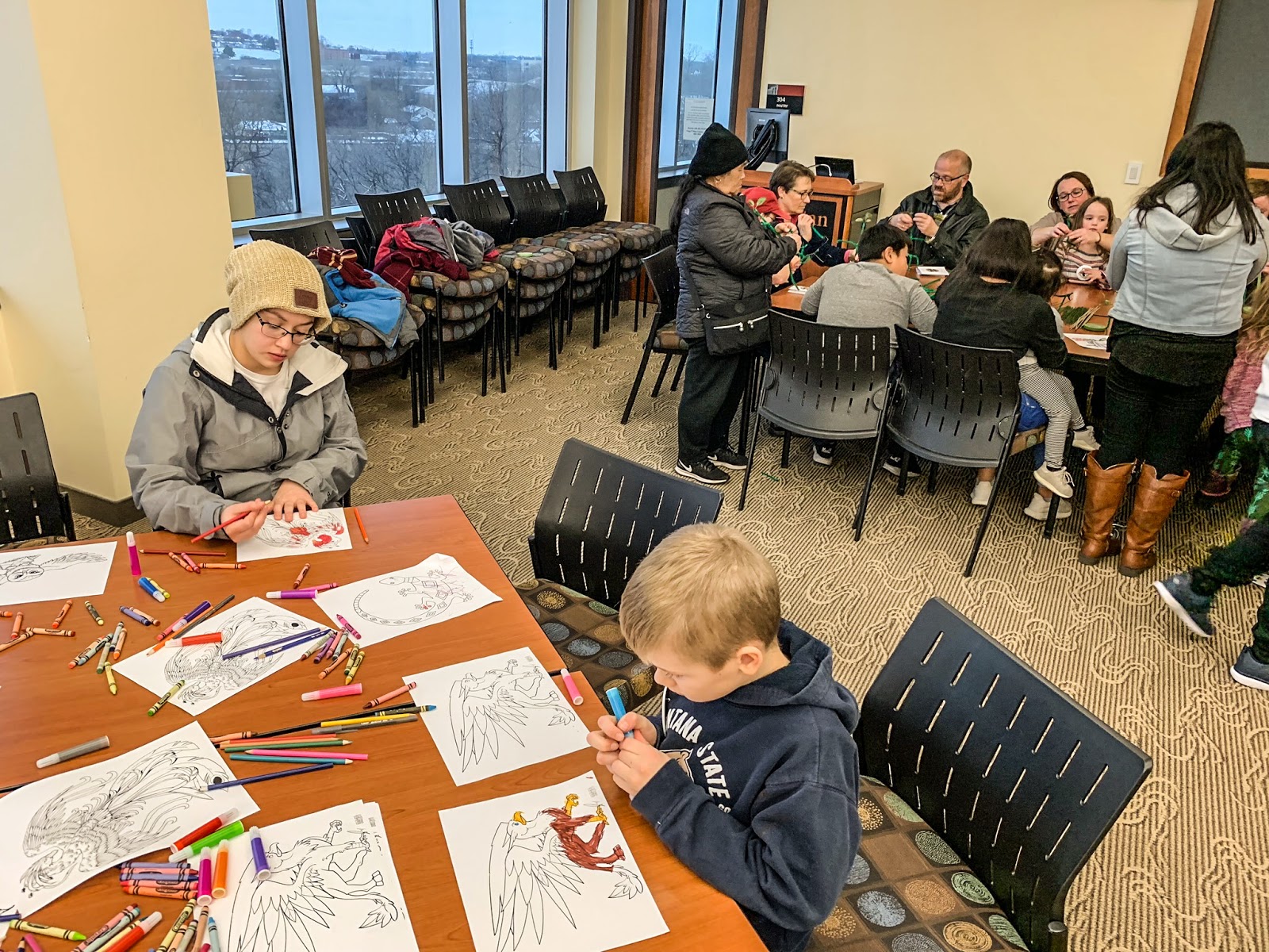 Participants color magical beasts, foreground, while others construct bowtruckles from green pipe cleaners at “Beastly Reads,” a Harry Potter-themed event at the Metropolitan State University Library and Learning Center on Saturday, Dec. 1, 2018. (Photo by J.D. Ganfield / The Metropolitan)
