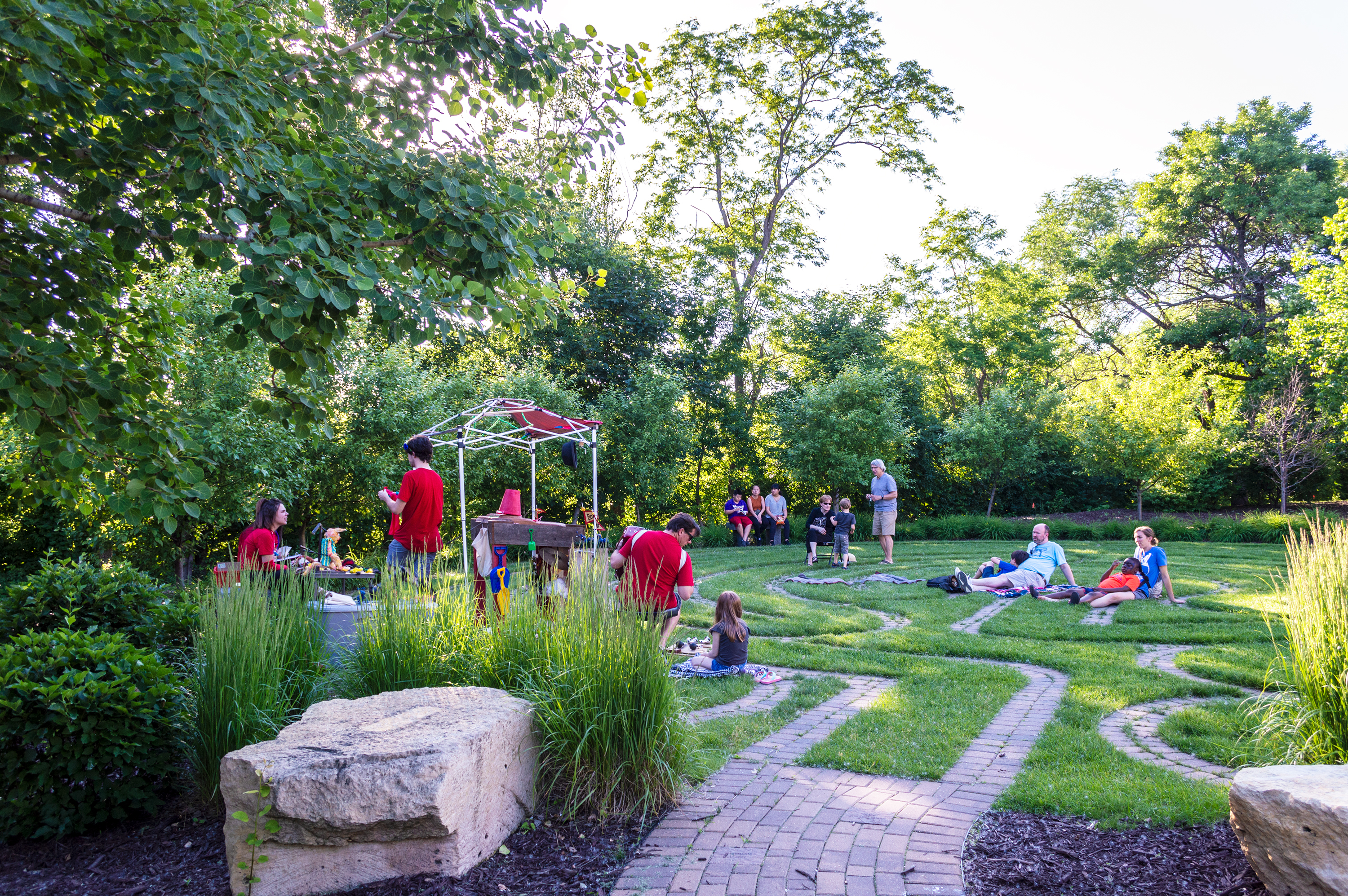 Open Eye Figure Theater members set the stage for their fifth summer performance in the David Barton Community Labyrinth and Reflective Garden on the grounds of Metro State’s Library and Learning Center. (Mandy Hathaway / The Metropolitan)